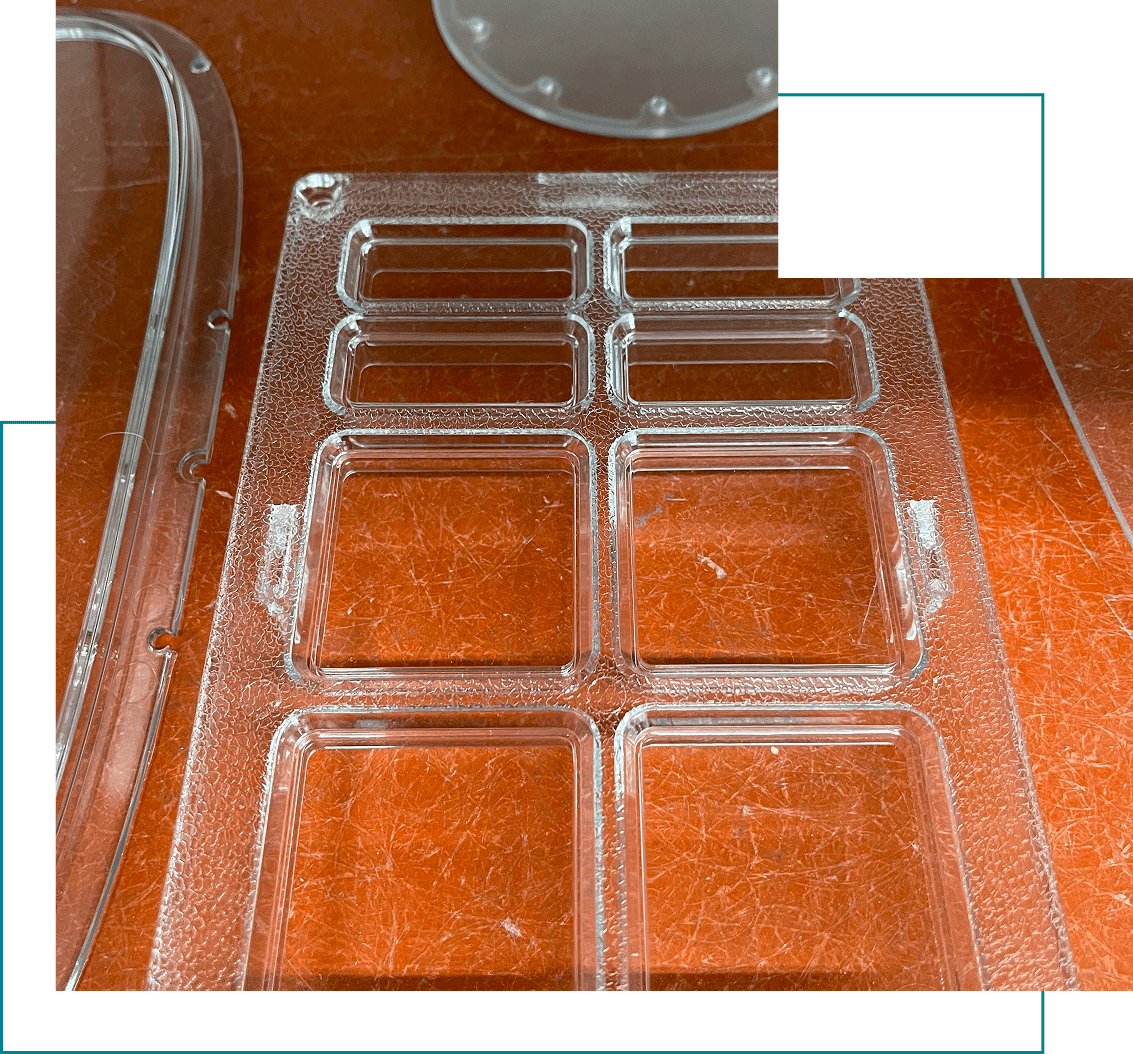 Clear plastic mold on orange surface.